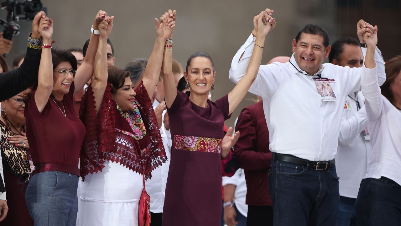 MEXICO CITY, MEXICO - MAY 29: Presidential candidate Claudia Sheinbaum of ''Sigamos Haciendo Historia'' coalition holds hands with members of her party during the 2024 closing campaign event at Zocalo on May 29, 2024 in Mexico City, Mexico. According to the Instituto Nacional Electoral (INE) over 100 million people are allowed to vote on the 2024 Presidential Election in Mexico. Claudia Sheinbaum of the Sigamos Haciendo Historia coalition, Xochitl Galvez of Fuerza y Corazón por México coalition and Jorge Alvarez Maynez of Movimiento Ciudadano will participate as the candidates for the presidency. (Photo by Hector Vivas/Getty Images)