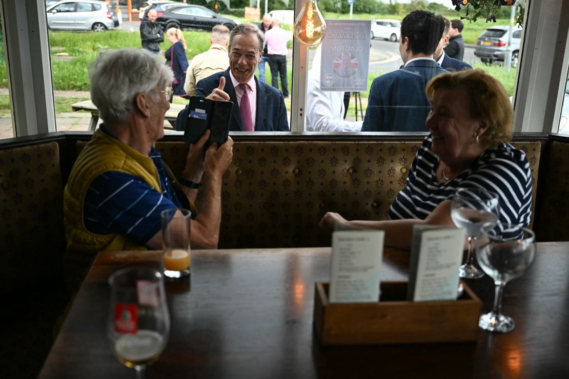 Nigel Farage, center, campaigning in Clacton. The Reform leader uses divisive language on migration, warning supporters of what he calls an "invasion" of asylum seekers.