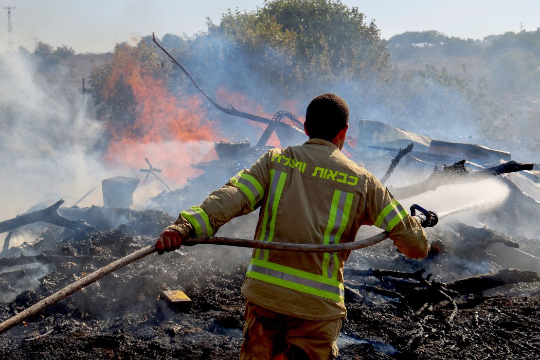 An Israeli firefighter puts out flames in a field after rockets launched from southern Lebanon landed on the outskirts of Kiryat Shmona on Tuesday.