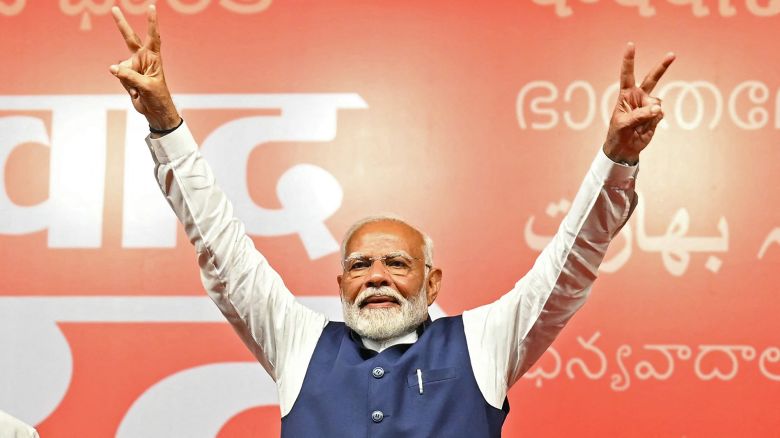 India's Prime Minister Narendra Modi flashes victory sign at the Bharatiya Janata Party (BJP) headquarters to celebrate the party's win in country's general election, in New Delhi on June 4, 2024