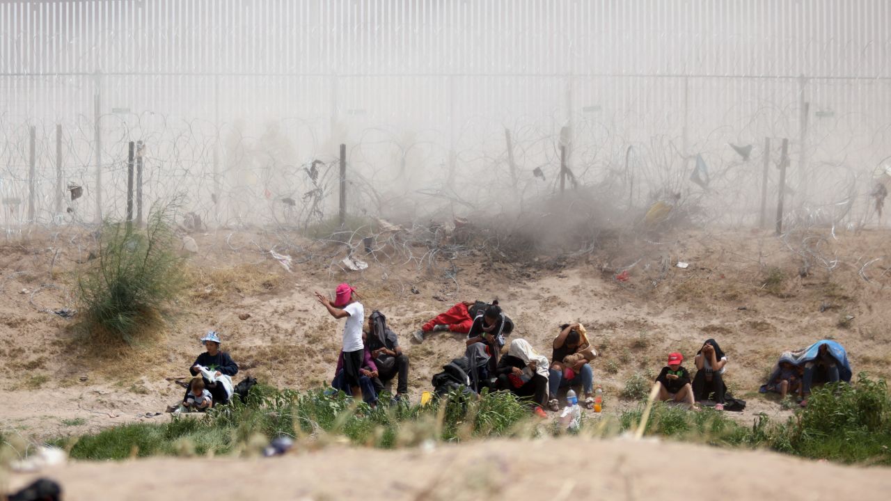 Migrants seeking asylum in the United States are watched by the Texas National Guard while they remain on the bank of the Rio Grande after having crossed from Ciudad Juarez, Chihuahua State, Mexico, on June 4, 2024. The United States will temporarily close its Mexico border to asylum seekers from Wednesday, as President Joe Biden as tries to neutralize his political weakness on migration ahead of November's election battle with Donald Trump. (Photo by HERIKA MARTINEZ / AFP) (Photo by HERIKA MARTINEZ/AFP via Getty Images)