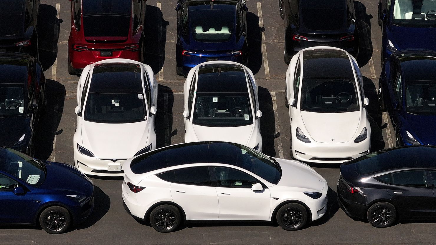 In an aerial view, brand new Tesla cars sit parked at a Tesla dealership in Corte Madera, California.