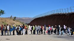 TOPSHOT - Migrants wait in line hoping for processing from Customs and Border Patrol agents after groups arrived at Jacumba Hot Springs, California, after walking under intense heat from Mexico into the US on June 5, 2024. Migrants from countries such as Turkey, Jordan, Guatemala, Nicaragua, China, India and Colombia made their way on foot into the United States today before being met with by Customs and Border Patrol agents for processing. The United States will temporarily close its Mexico border to asylum seekers starting today, June 5, as President Joe Biden as tries to neutralize his political weakness on migration ahead of November's election battle with Donald Trump. The 81-year-old Democrat signed a long-awaited executive order taking effect at midnight to "gain control" of the southern frontier with Mexico, after record numbers of illegal border crossings sparked concerns among voters. (Photo by Frederic J. BROWN / AFP) (Photo by FREDERIC J. BROWN/AFP via Getty Images)