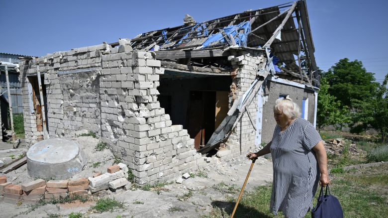 Raisa Abramtseva, 68, walks past her heavily damaged house in the village of Novovorontsovka, Kherson region, on June 3, 2024, amid the Russian invasion of Ukraine.