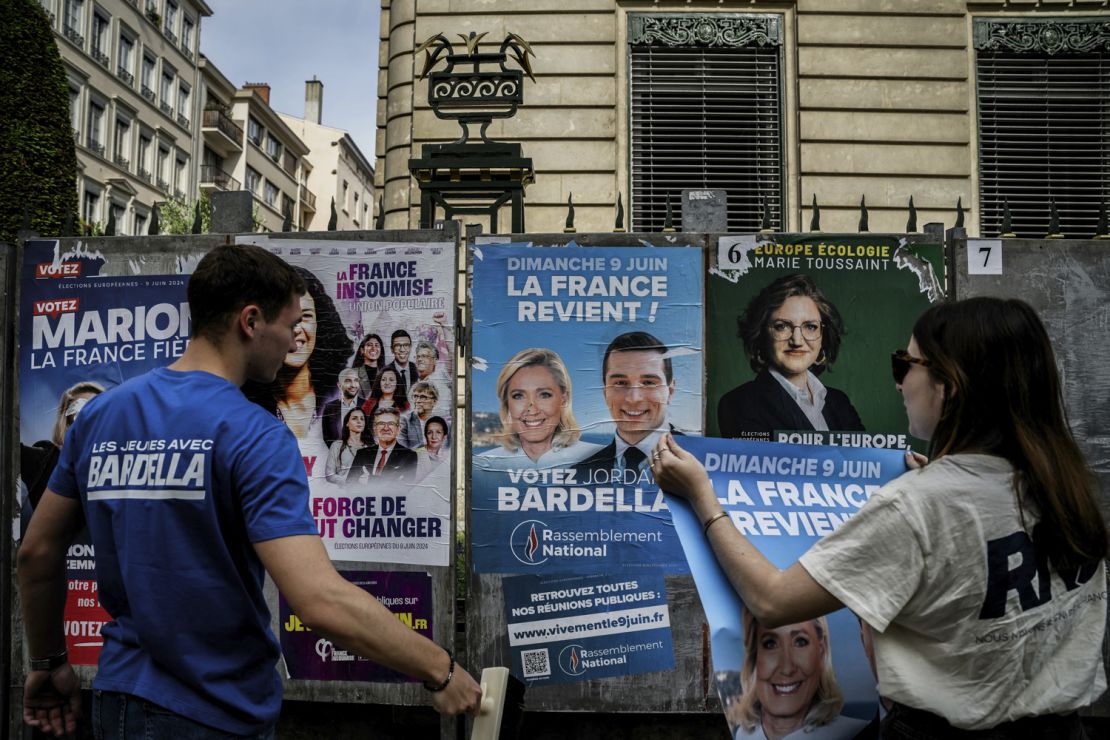 France's far-right Rassemblement National (RN) party volunteers paste campaign posters ahead of the June 9 European Parliament elections.