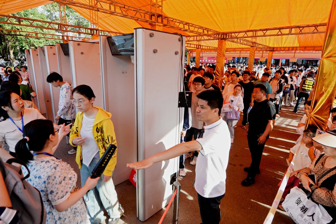 Students line up to undergo a security check outside a school on the first day of school 