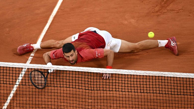 PARIS, FRANCE - JUNE 03: Novak Djokovic of Serbia slides at the net for a forehand against Francisco Cerundolo of Argentina in the Men's Singles fourth round match during Day Nine of the 2024 French Open at Roland Garros on June 03, 2024 in Paris, France. (Photo by Clive Mason/Getty Images)