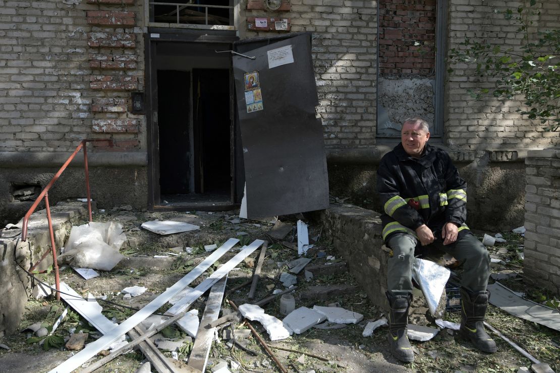 A rescuer rests next to a destroyed residential building in Luhansk.