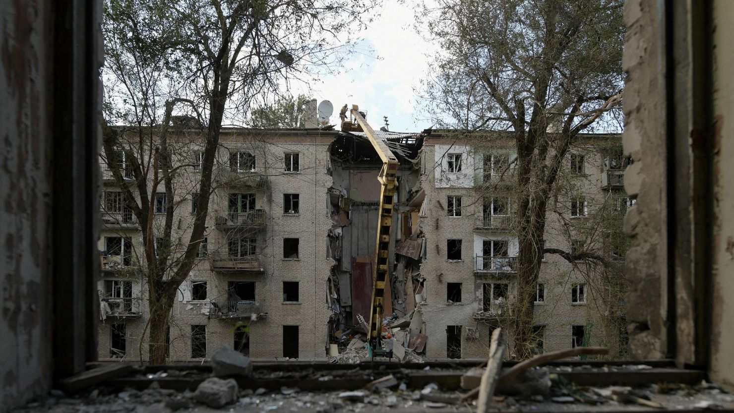 Rescuers clear the rubble of a destroyed residential building following a missile attack in Luhansk.