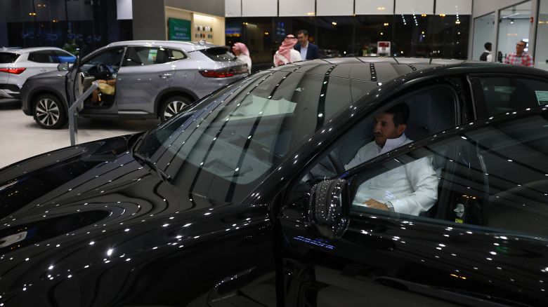 A man inspects an electric car at a showroom in Riyadh on June 8, 2024. Although the EV market in the world's largest oil exporter remains small compared with the United States and China, it tripled last year to nearly 800 cars, according to Saudi business news outlet Al-Iqtisadiyah.