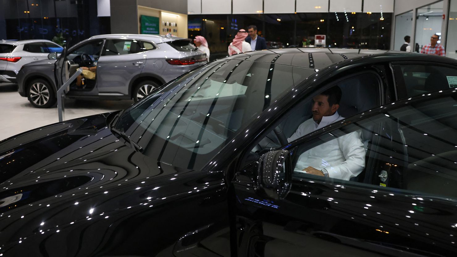 A man inspects an electric car at a showroom in Riyadh in June 2024.