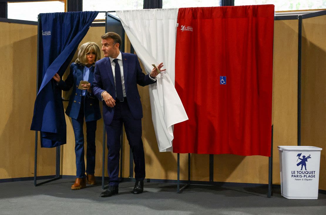 El presidente de Francia, Emmanuel Macron, y su esposa Brigitte salen de una cabina electoral antes de depositar su voto para las elecciones al Parlamento Europeo en un colegio electoral en Le Touquet, en el norte de Francia, en junio.