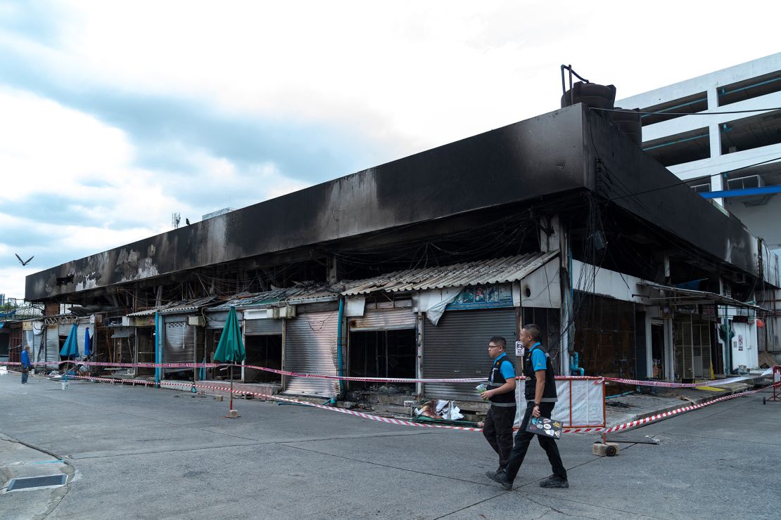 Forensics officers survey the area following the fire.