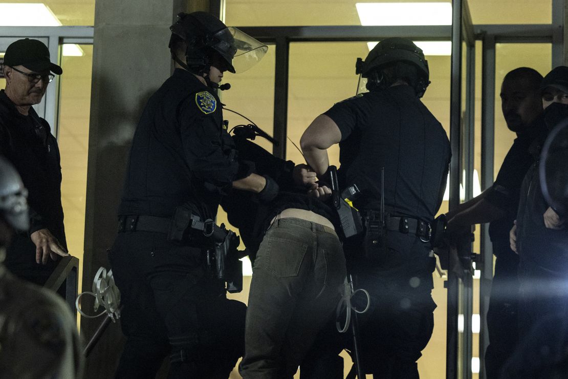 A pro-Palestinian protester is detained outside Dodd Hall at the University of California, Los Angeles on Monday.
