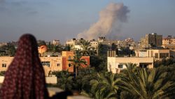 TOPSHOT - A Palestinian woman watches as smoke billows following an Israeli strike south of Gaza City, in the town of al-Zawaida in the central Gaza Strip, on June 11, 2024 amid the ongoing conflict between Israel and the Palestinian militant group Hamas. (Photo by Eyad BABA / AFP) (Photo by EYAD BABA/AFP via Getty Images)