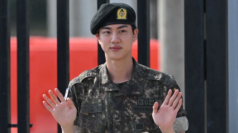 K-pop boy band BTS member Jin waves after being discharged from his mandatory military service outside a military base in Yeoncheon, South Korea on June 12, 2024. Jin the first member of the band to complete the mandatory duty, freeing him up to fully resume musical activities.