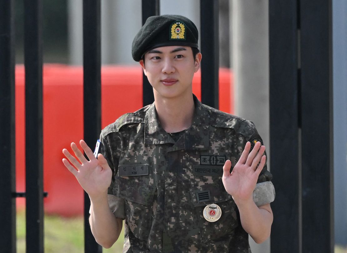 K-pop boy band BTS member Jin waves after being discharged from his mandatory military service outside a military base in Yeoncheon, South Korea on June 12, 2024. Jin the first member of the band to complete the mandatory duty, freeing him up to fully resume musical activities.