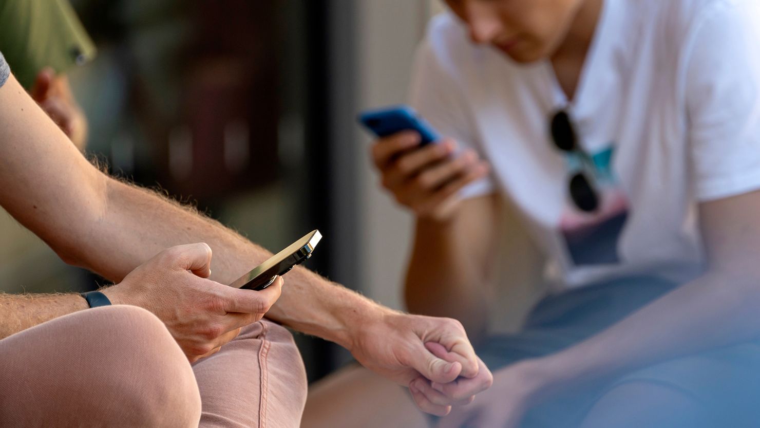 Customers use iPhones in front of an Apple store in San Francisco, California on Tuesday, June 11, 2024.