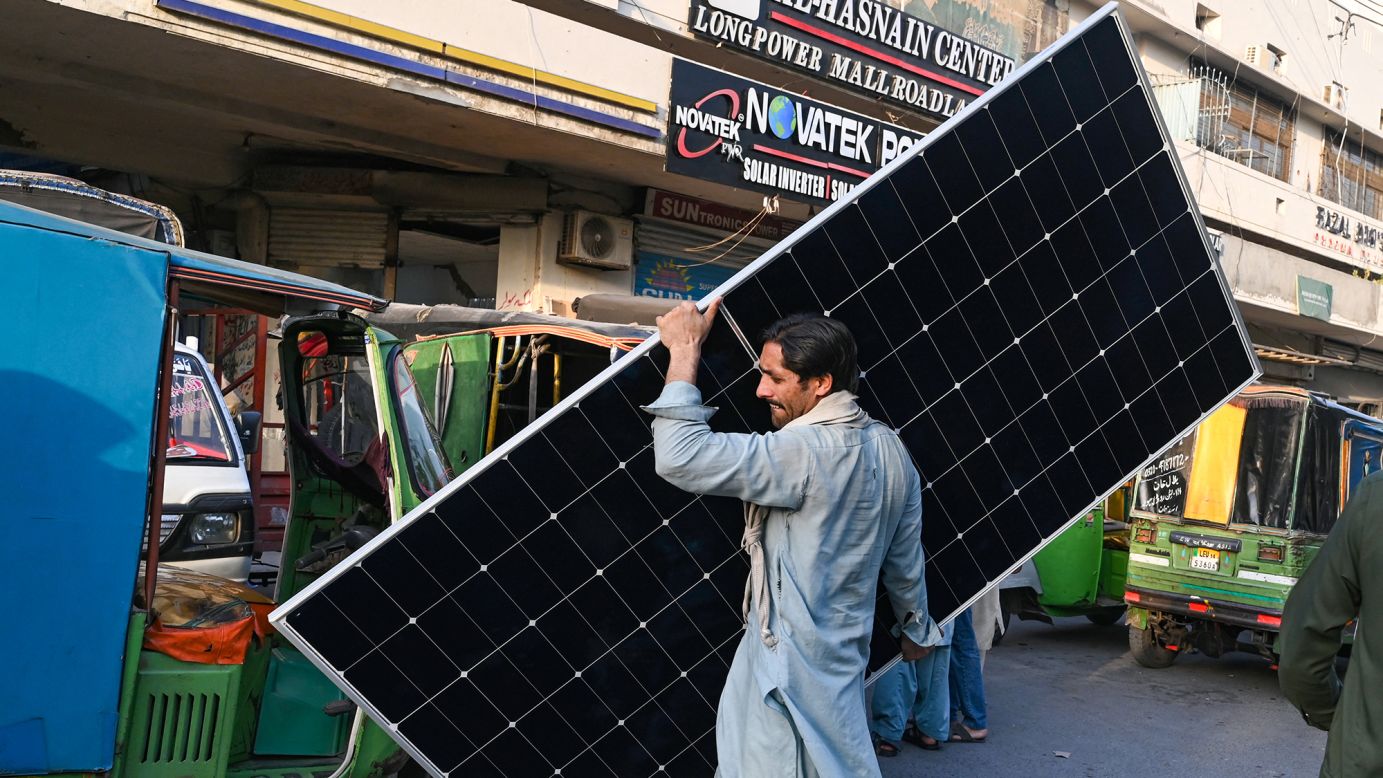 A worker carries a solar panel plate at a market in Lahore on June 12, 2024. The country has experienced a rapid solar boom over the past two years.