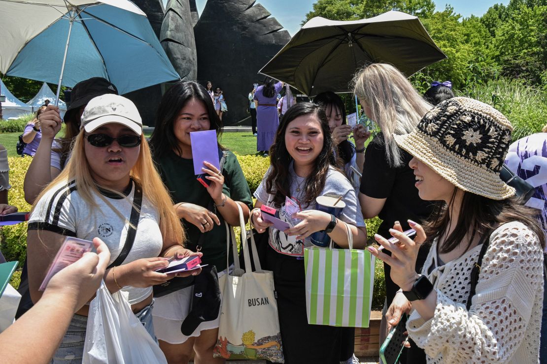 Fans of K-pop boy band BTS swap cards as they attend the event in Seoul on June 13, 2024.