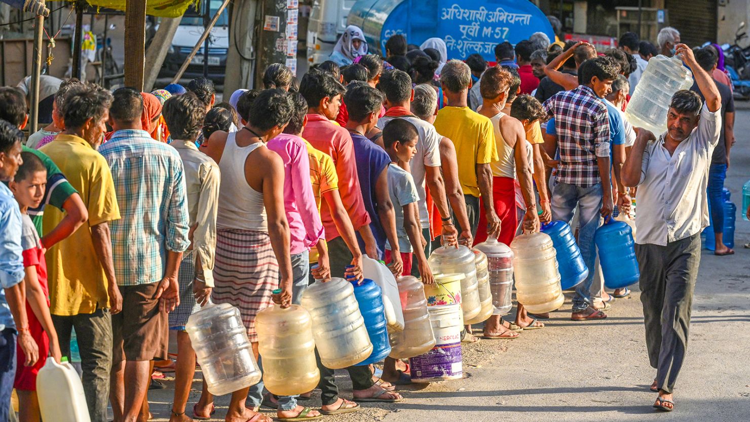 People queue to fill water from a tanker during a heat wave at Chilla Village on June 13, 2024 in New Delhi, India.