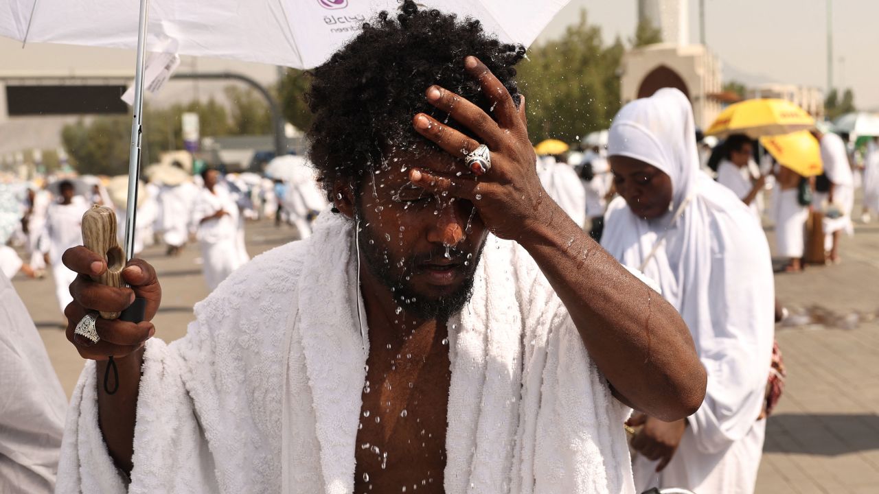A Muslim pilgrim splashes water on his head to cools off at the base of Saudi Arabia's Mount Arafat, also known as Jabal al-Rahma or Mount of Mercy, during the climax of the Hajj pilgrimage on June 15, 2024. More than 1.5 million Muslims will pray on Mount Arafat in soaring temperatures on June 15, in the high-point and most gruelling day of the annual Hajj pilgrimage, one of the five pillars of Islam that must be performed at least once by all Muslims who have the means to do so. (Photo by Fadel Senna / AFP) (Photo by FADEL SENNA/AFP via Getty Images)