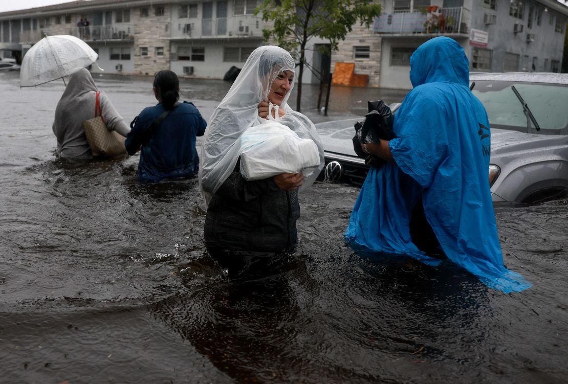 People walk through a flooded street in Hollywood, Florida, on June 12, 2024.