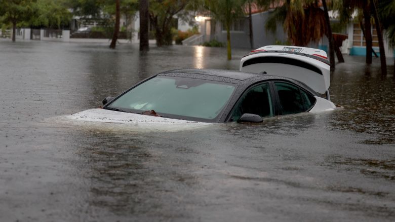 A vehicle sits in flood waters in Hollywood, Florida on June 12, 2024. As tropical moisture passes through the area, areas have become flooded due to the heavy rain.
