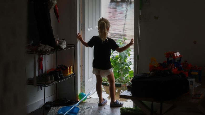 Vera Kalnichenko looks out at the flood waters from her parents' friend's home in Hallandale Beach, Florida, after about eight inches of flood water inundated it on June 13, 2024.