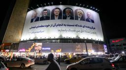 Vehicles move past a billboard displaying the faces of the six candidates running in the upcoming Iranian presidential election in Valiasr Square in central Tehran on June 17, 2024. (Photo by ATTA KENARE / AFP) (Photo by ATTA KENARE/AFP via Getty Images)