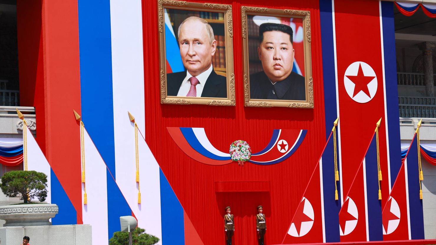 Guards stand underneath portraits of North Korea's leader Kim Jong Un and and Russian President Vladimir Putin during Putin's visit to Pyongyang on June 19, 2024.
