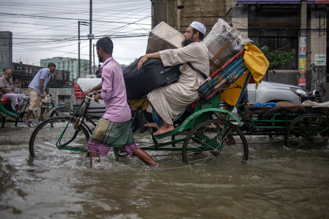 People are moving through a flooded street in Sylhet city, Sylhet, Bangladesh, on Thursday, June 20, 2024. In Sylhet, lashing rain and rivers swollen by flooding upstream in India are also swamping heavily populated areas. (Photo by Syed Mahamudur Rahman/NurPhoto via Getty Images)