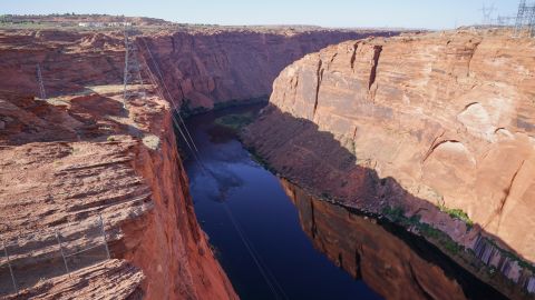 TOPSHOT - An aerial view of the Colorado River side of the Glen Canyon Dam, which separates the Colorado River from Lake Powell,  in Page, Arizona on June 18, 2024. Lake Powell is the second largest reservoir in the US and can hold more than 23 million acre feet (2,837,024,700,000 hectare meter) of water. It's currently just under 39% full and still taking in water from what's left of Spring runoff. The drought conditions and population growth has been a continual stress on water throughout the southwest. (Photo by Bryan R. SMITH / AFP) (Photo by BRYAN R. SMITH/AFP via Getty Images)