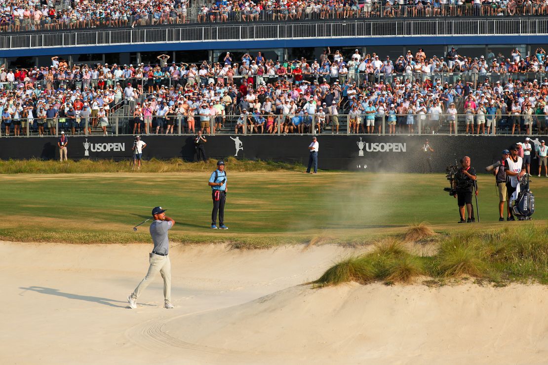 DeChambeau plays his bunker shot on the 18th hole, a shot which he calls “possibly my best golf shot of my entire life.”