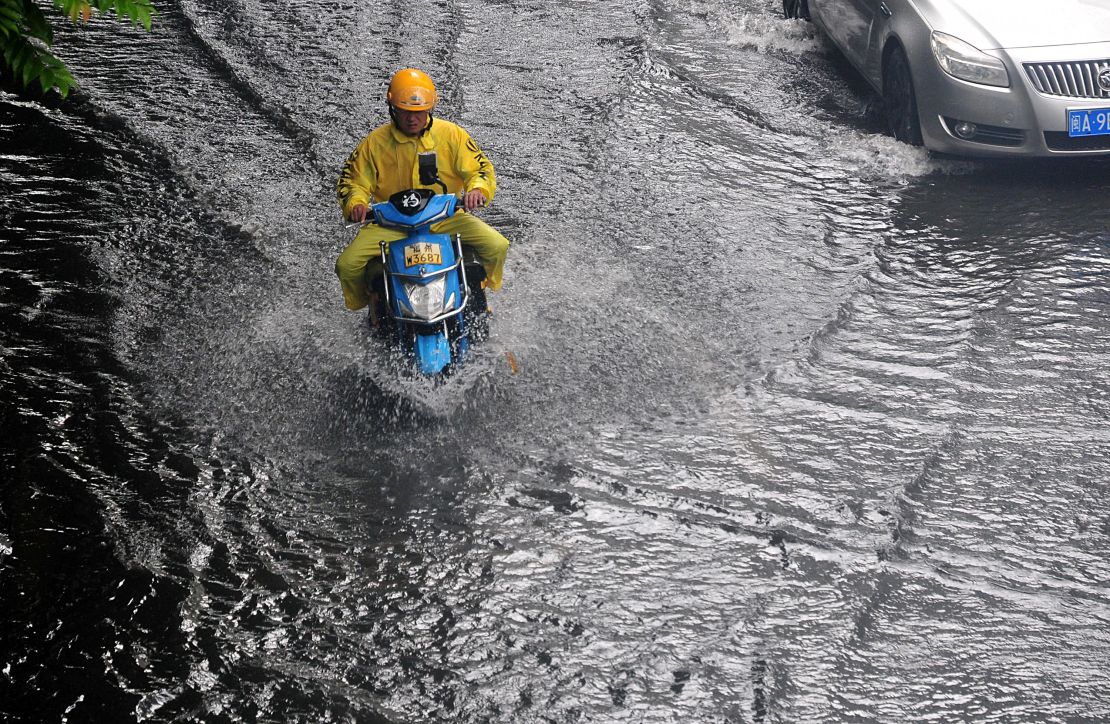 A commuter navigates a waterlogged road after heavy rain in Fuzhou, in China's Fujian province, on June 16.