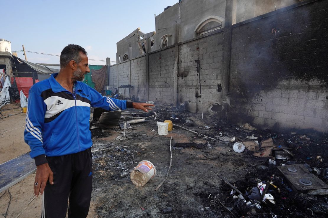 A Palestinian man points to ashes in a tented area, the day after a strike on Mawasi.