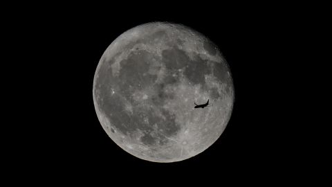 FOSTER CITY, CALIFORNIA - JUNE 22: A passenger plane flies in front of the full 'strawberry' moon over San Francisco Bay as seen from Foster City in California, United States on June 22, 2024. (Photo by Tayfun Coskun/Anadolu via Getty Images)