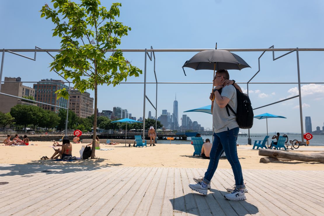 People relax at an artificial beach in Manhattan on a sweltering afternoon on the first full day of summer on June 21, 2024, in New York City.