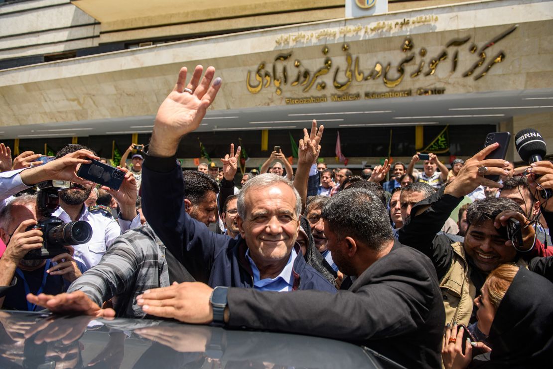 Masoud Pezeshkian, Iranian presidential election candidate and lawmaker waves to the crowd after casting his vote at a polling station in Tehran, Iran on Friday.