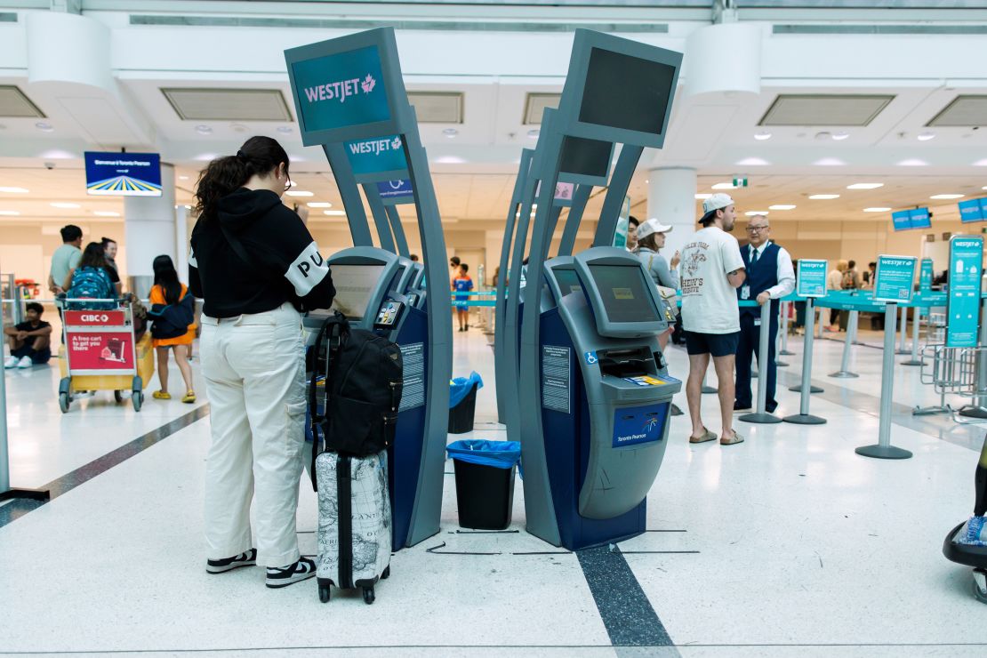 Travelers at a Westjet check-in counter in Toronto Pearson International Airport on June 30, 2024.