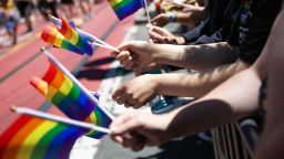 Parade goers hold Pride flags during the annual Pride Parade in San Francisco on June 29, 2024.