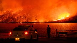 TOPSHOT - Law enforcement members watch as the Thompson fire burns over Lake Oroville in Oroville, California on July 2, 2024. A heatwave is sending temperatures soaring resulting in red flag fire warnings throughout the state. (Photo by JOSH EDELSON / AFP) (Photo by JOSH EDELSON/AFP via Getty Images)