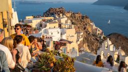 Travellers enjoying every bit of free space to admire the sunset at Oia on the island of Santorini, 30 June 2024. With the uncontested growth in the number of visitors to the island of Santorini, the authorities are beginning to think about imposing certain limits on the number of travellers. (Photo by Xavier Duvot / Hans Lucas / Hans Lucas via AFP) (Photo by XAVIER DUVOT/Hans Lucas/AFP via Getty Images)