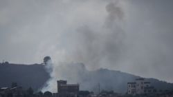 RMAICH, LEBANON - JUNE 30:  Smoke rises behind buildings from an Israeli strike against a Hezbollah target on the town of Aita al Chaab on June 30, 2024 in Rmaich, Lebanon. Hezbollah and the Israeli Defense Forces (IDF) have been trading cross-border fire since the October 7 attacks, with the conflict escalating in May when the group launched a missile-carrying drone against Israel for the first time. The conflict intensified in June when Hezbollah fired hundreds of rockets and drones at Israeli military sites following the killing of senior commander Taleb Abdullah. This marked the largest assault since October 8. The last significant conflict between Israel and Hezbollah occurred in 2006, lasting 34 days and resulting in a stalemate (Photo by Chris McGrath/Getty Images)