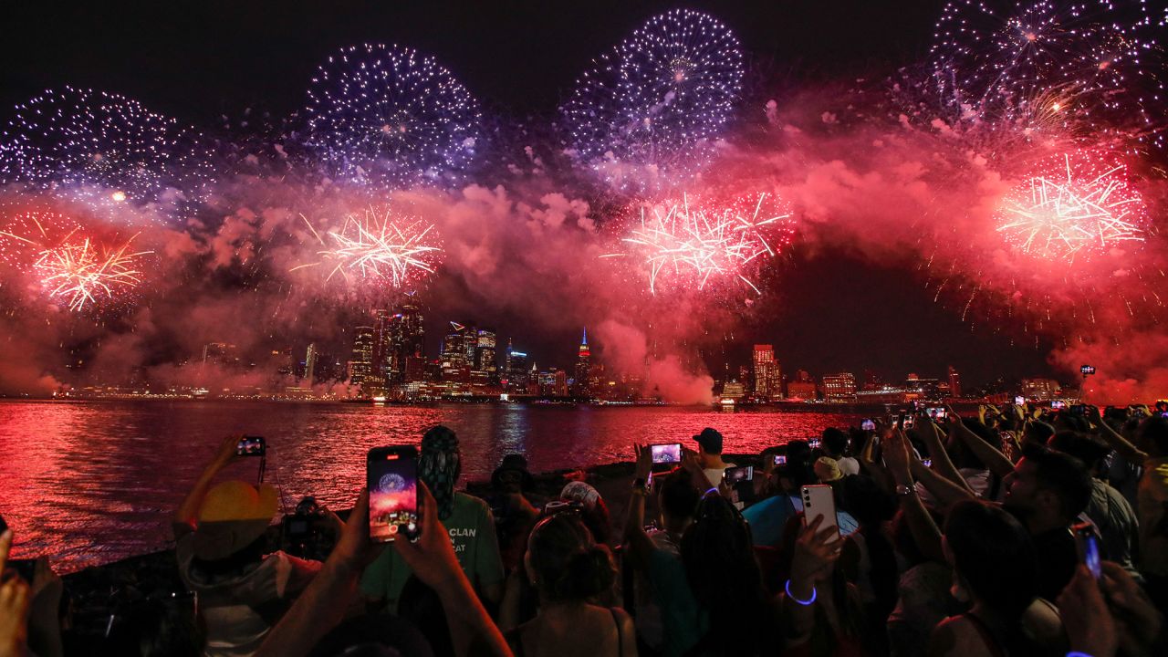 People gather near the Hudson River during the annual Macy's Independence Day fireworks show as seen from Hoboken, New Jersey, on July 4, 2024.