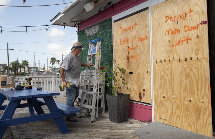 A worker boards up windows at an ice cream parlor in Port Aransas, Texas, on Saturday.