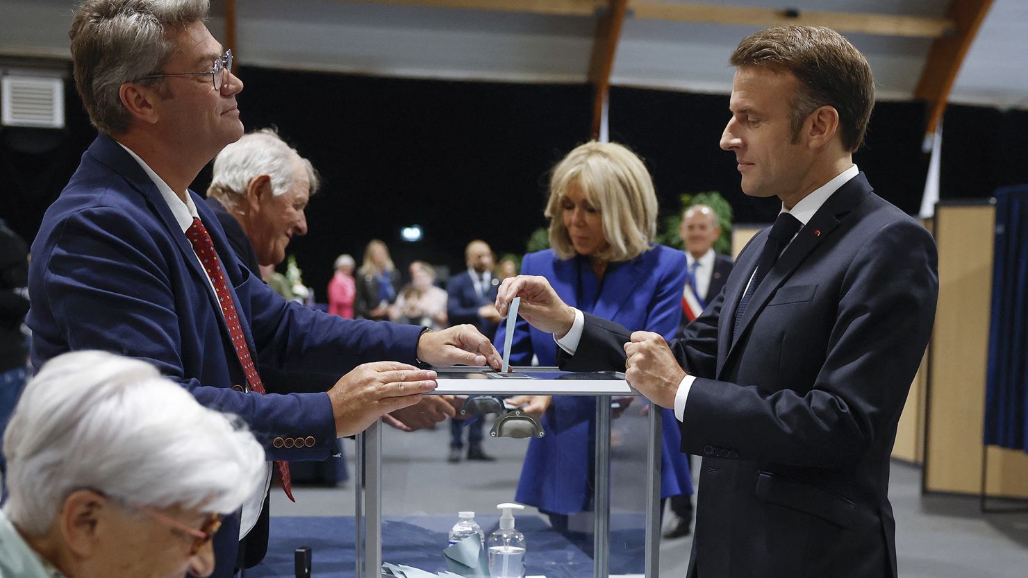 French President Emmanuel Macron, with wife Brigitte in the background, cast their ballots in the second round of France's legislative election on July 7. His centrist Ensemble alliance came second after the leftist New Popular Front coalition.