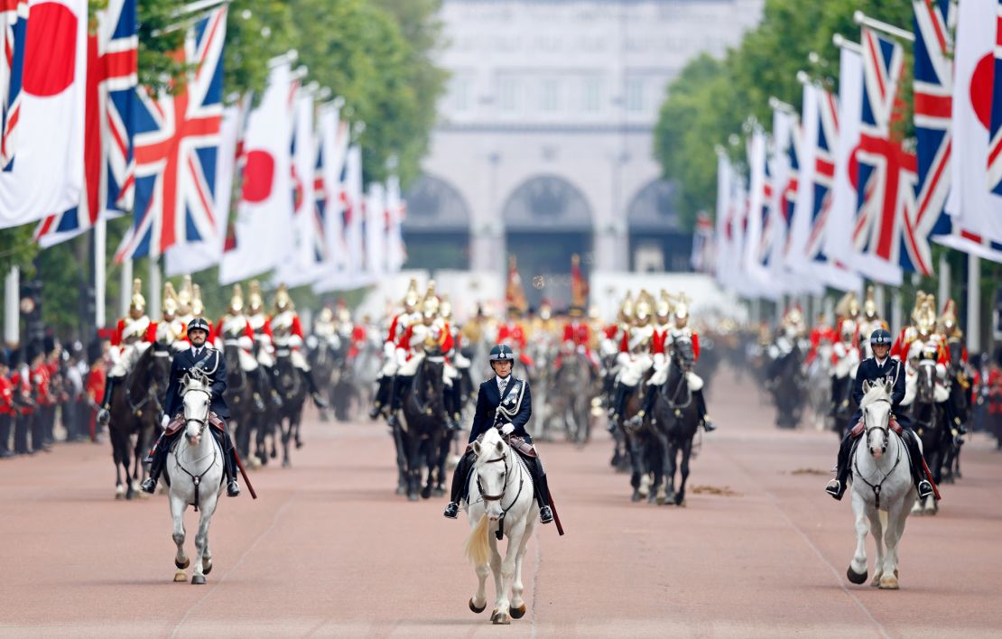 Mounted police officers lead a carriage procession carrying King Charles III, Emperor Naruhito of Japan, Queen Camilla, Empress Masako of Japan and Prince William down The Mall -- lined with Japanese and Union flags -- to Buckingham Palace on June 25, 2024.