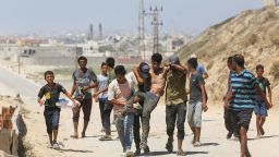 DEIR AL-BALAH, GAZA - JULY 08: Palestinians, heading towards Gaza city to meet their relatives after Israel's evacuation warning, carry a Palestinian man injured in the Israeli attack after Israeli army ordered Palestinian residents in several areas in the Gaza Strip on Monday to evacuate immediately in Deir al-Balah, Gaza on July 08, 2024. Palestinians leave their homes after the Israeli army informed the Palestinians in the Al Sabra, Rimal, Tel Alhava and Al-Derc areas of Gaza City to evacuate their areas. (Photo by Ashraf Amra/Anadolu via Getty Images)