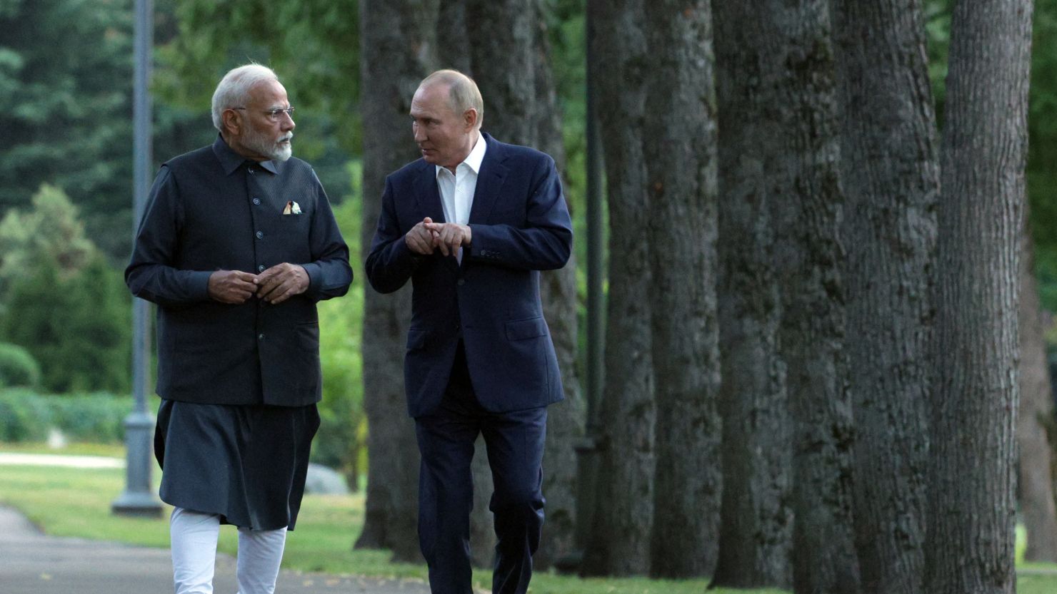 In this pool photograph distributed by the Russian state agency Sputnik, Russia's President Vladimir Putin and Indian Prime Minister Narendra Modi take a walk during an informal meeting at the Novo-Ogaryovo state residence, outside Moscow, on July 8, 2024. (Photo by Gavriil GRIGOROV / POOL / AFP) (Photo by GAVRIIL GRIGOROV/POOL/AFP via Getty Images)